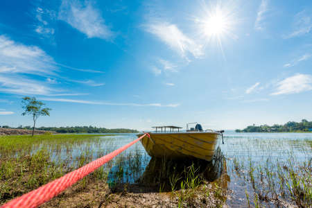 The boat in lake under beautiful clouds with blue sky and sunの写真素材