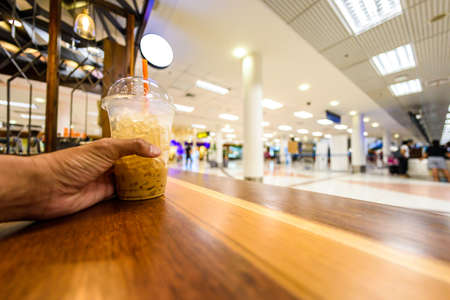 Hands of a man drinking coffee while waiting in airport.