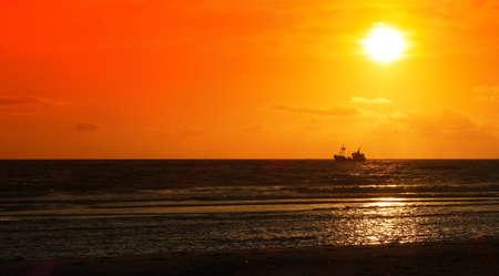 fishing boat in the sunsetの写真素材