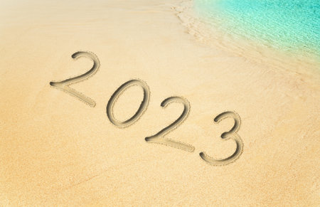 New Year 2023 written in sand on the beach