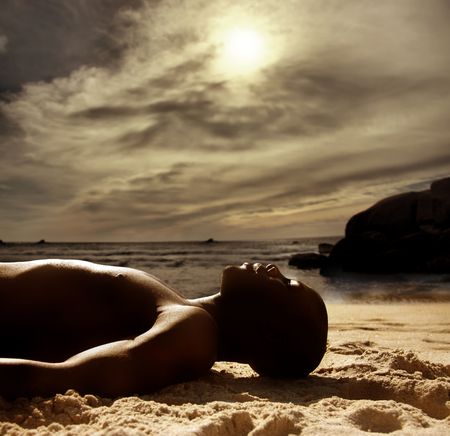 black man laying on the beach の写真素材