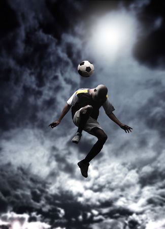 afrcican soccer player heading a ball in a stormy weatherの写真素材