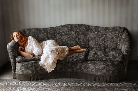 beautiful woman sleeping on a vintage sofaの写真素材
