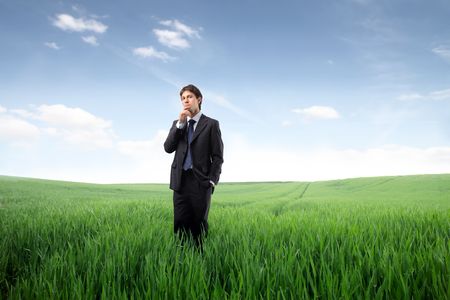 Businessman standing on a green meadowの写真素材