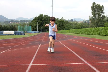 Child running on a running trackの写真素材