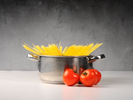Spaghetti in a pot with tomatoesの写真素材