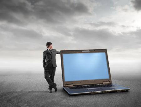 Businessman standing beside a laptopの写真素材
