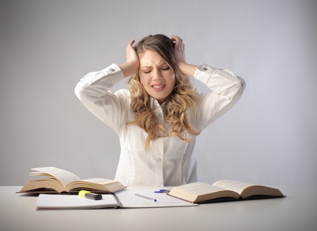 Stressed student sitting in front of some booksの写真素材