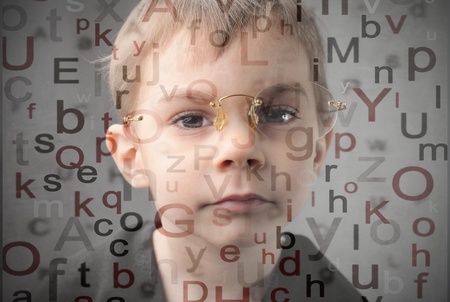 Child wearing glasses and alphabet letters on the backgroundの写真素材