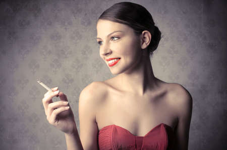 Smiling beautiful woman holding a cigaretteの写真素材