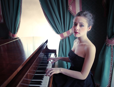 Beautiful woman playing the pianoの写真素材