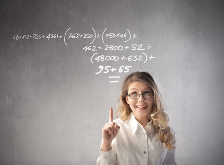 Smiling businesswoman indicating a calculation over her headの写真素材