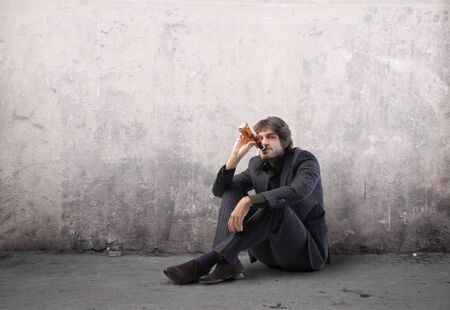 Businessman drinking a beer on a street
