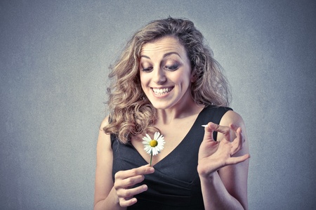 Smiling beautiful woman wavering a daisyの写真素材