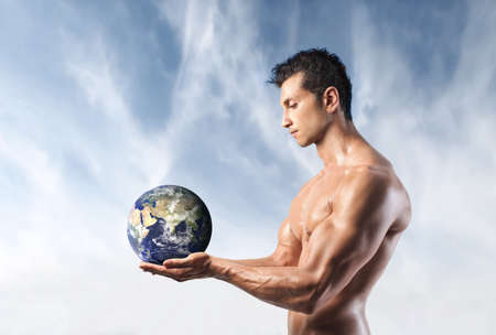 Muscular man holding the Earth in his handsの写真素材