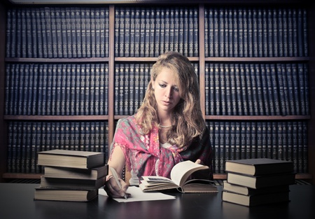 Woman in a library reading a bookの写真素材