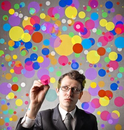 Young businessman drawing some colored circlesの写真素材