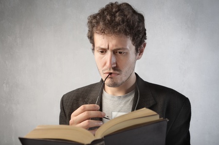 Concentrated young man reading a bookの写真素材