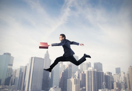 Businessman running with cityscape in the backgroundの写真素材