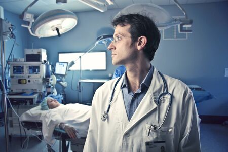 Surgeon in an operating room with patient in the background