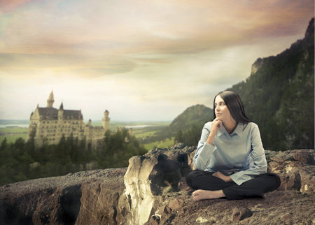 Beautiful woman with thoughtful expression and fairy tale castle in the backgroundのeditorial素材