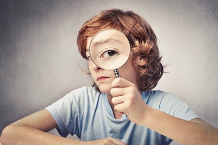 Child looking through a magnifying glass Child looking through a magnifying glass