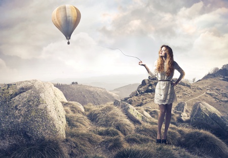 Beautiful woman with hot-air balloon in the backgroundの写真素材