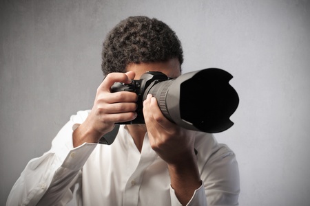 Young photograph pointing a reflex camera to take picturesの写真素材