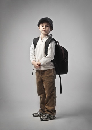 Child carrying a backpack on his shouldersの写真素材