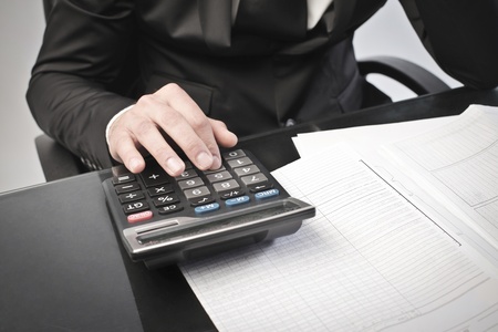 Closeup of a businessman using a calculator