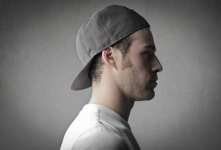 Profile of a handsome young man wearing a peaked capの写真素材