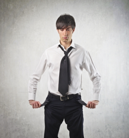 Sad young businessman turning his pockets inside outの写真素材