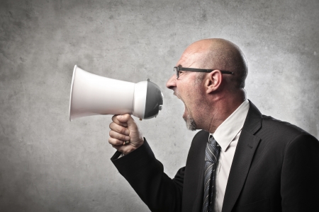 Businessman screaming into a megaphoneの写真素材