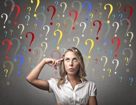 Blonde woman with many colored question marks on her headの写真素材