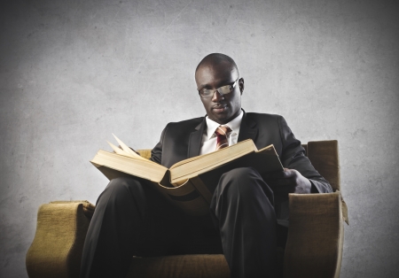 Black businessman reading a big bookの写真素材