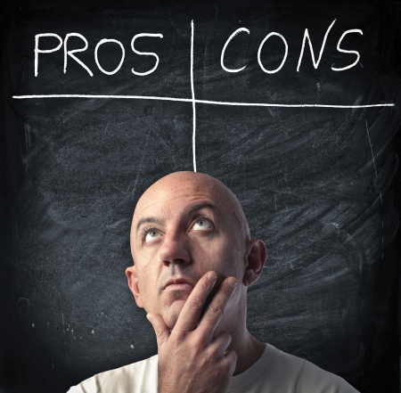 Man reflecting on the pros and the cons of a choiceの写真素材