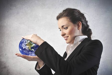 Businesswoman holding the world in her handsの写真素材
