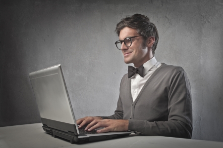 Fashionable man using a laptop computerの写真素材