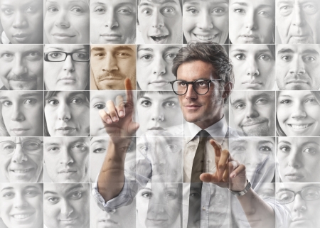 businessman touch screen with virtual facesの写真素材