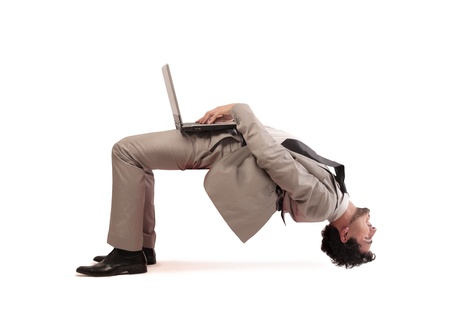 Young businessman using a laptop computer upside downの写真素材