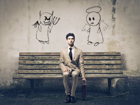 elegant man sitting on a bench waiting for undecidedの写真素材