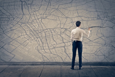 young businessman writes on the map