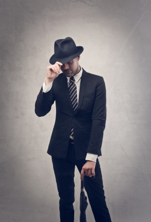 young businessman with hat and umbrellaの写真素材