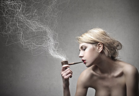 beautiful blonde woman smokes a pipeの写真素材