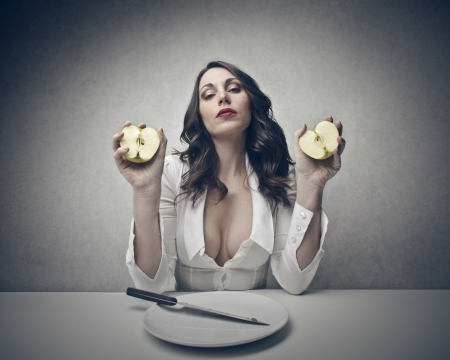 sensual woman shows a cut appleの写真素材
