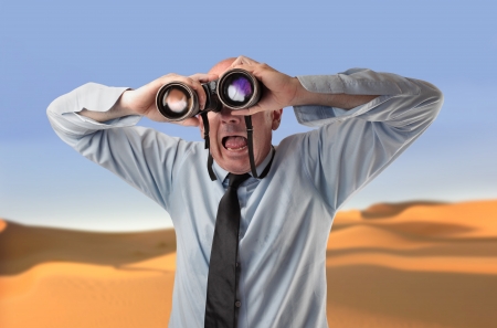 scared businessman using a binocularsの写真素材