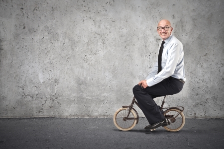businessman riding a small bikeの写真素材