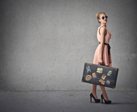 fashion woman with her suitcase ready to leaveの写真素材