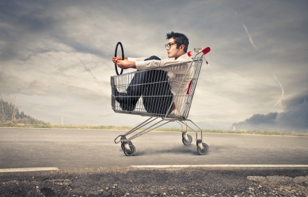 businessman into a cart pretending to drive a carの写真素材