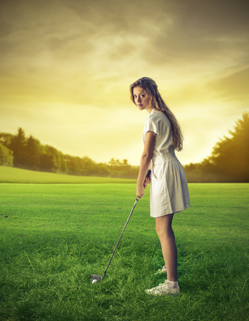 young woman playing golfの写真素材